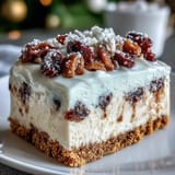 A close-up of the creamy Christmas Cheesecake Slab, revealing spiced dried fruits and a crunchy biscuit crust.