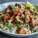 Hearty Peanut Chicken Protein Bowl featuring golden chicken, fresh cilantro, and crunchy red cabbage on a bed of fragrant coconut rice.