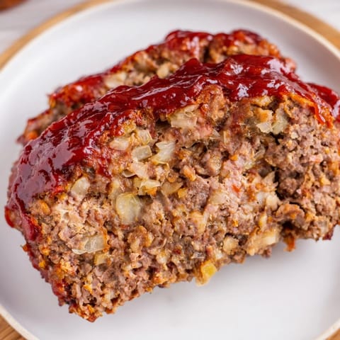 A close-up of a perfectly browned meatloaf, flavorful and juicy, perfect comfort food.