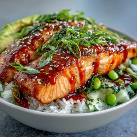 A close-up of Honey Sriracha Salmon Bowl with glazed salmon, edamame, and creamy avocado.
