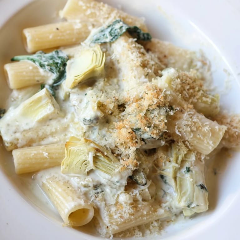Freshly baked Artichoke Pasta Bake with golden breadcrumbs, spinach, and al dente pasta in a creamy sauce.