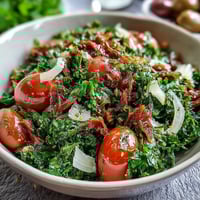 Bright dandelion greens salad with cherry tomatoes, red onion, and Parmesan, dressed in tangy lemon vinaigrette.  